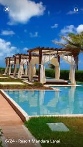 a swimming pool with a pavilion and a swimming pool at Mandara Lanai in Aquiraz