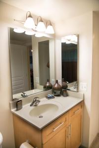 a bathroom with a sink and two mirrors at Crystal Quarters Corporate Housing at The Gramercy in Arlington