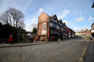 a cobblestone street in a town with a building at Lymm Village Apartment in Lymm