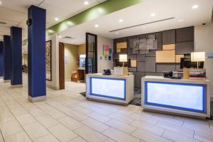 a lobby with two large screens in a store at Holiday Inn Express & Suites Lexington Park California, an IHG Hotel in California
