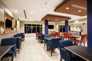 a dining room with tables and chairs at Holiday Inn Express & Suites Lexington Park California by IHG in California