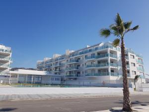 duży budynek z palmą przed nim w obiekcie Apartamento Lujo Duna Beach w mieście Torrox Costa