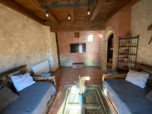 a living room with two beds and a glass table at CASA LA JUDERÍA in Gea de Albarracín