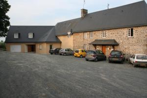 a large brick building with cars parked in a parking lot at Le Relais Postal in Courson