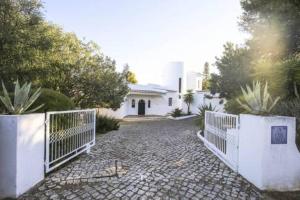 une clôture blanche devant une maison dans l'établissement Casa Carioca, à Benagil