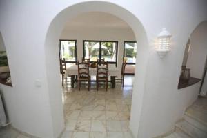 an archway in a dining room with a table and chairs at Casa Carioca in Benagil