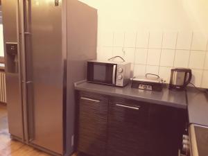 a kitchen with a microwave and a refrigerator at Monteurwohnung - Business Apartment in Wertheim