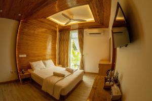 丹格迪的住宿－PERLA Dhangethi，一间卧室设有一张大床和一个窗户。