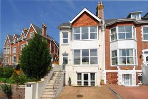 a large house with a staircase in front of it at High Gables Apartment 2 in Paignton