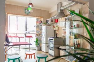 a kitchen with a refrigerator and a table and stools at Paz & Amor Guest House - Peace & Love in Nazaré