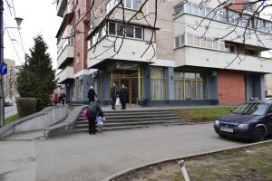 una persona con un ombrello in piedi di fronte a un edificio di Apartament Zippi Republicii RHBM a Baia Mare