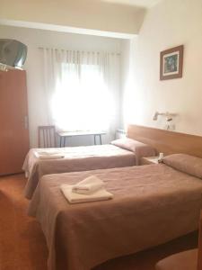 a hotel room with two beds with towels on them at PENSION MIRAFLORES in Zaragoza +18 photos