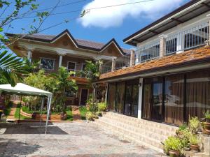 a house with a balcony on top of it at Villa Marii in Dipolog