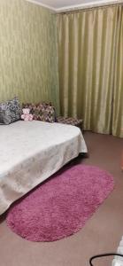 a bedroom with a bed with a pink rug at Старошишковская улица, 7 квартира 142 Апартаменты in Kharkiv
