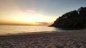 een zonsondergang op een strand met de oceaan bij Home No.9 in Koh Lanta