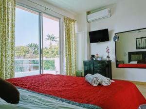 1 dormitorio con cama roja y ventana grande en La Terraza en Tuxtla Gutiérrez