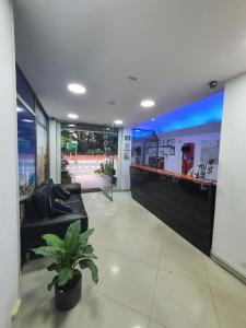 a lobby with a couch and a bar in a building at Hotel Laureles Park in Medellín