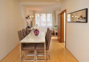a dining room table with chairs and a vase on it at Selinor Old Town Apartments in Prague