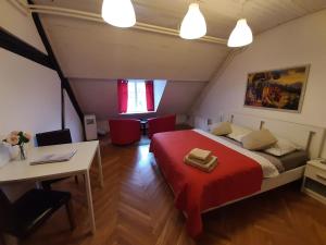 a bedroom with a red bed and a table and chairs at VIKSI hostel in Ljubljana