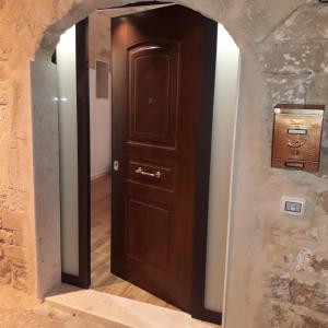 um corredor com uma porta de madeira numa parede de pedra em Sant'Onofrio apartment em Bari