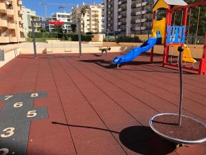 un parque infantil con un tobogán azul en una ciudad en Paradise Luxury Apartment - Praia da Rocha, en Portimão