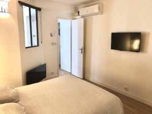 ein Schlafzimmer mit einem Bett und einem TV an der Wand in der Unterkunft Appartement T2 de 40m2 refait à neuf pour vous ! Climatisé in La Grande-Motte