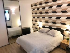 een slaapkamer met een bed en een grote spiegel bij Appartement T2 de 40m2 refait à neuf pour vous ! Climatisé in La Grande-Motte