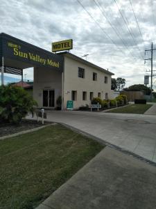 a large building with a sign on the side of it at Sun Valley Motel Biloela in Biloela