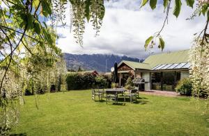a patio with a table and chairs in a yard at The Billiards Room in Queenstown