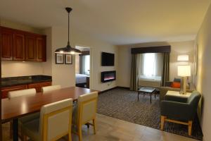 a living room and dining room with a table and chairs at Holiday Inn Hotel & Suites Minneapolis-Lakeville by IHG in Lakeville