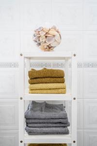 a white shelf with towels and a basket on it at Mouzinho Blueapartment in Cabanas de Tavira