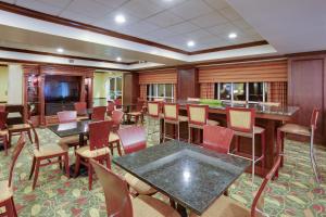 a restaurant with tables and chairs and a bar at Holiday Inn Express Hotel & Suites Charleston-Ashley Phosphate, an IHG Hotel in Charleston