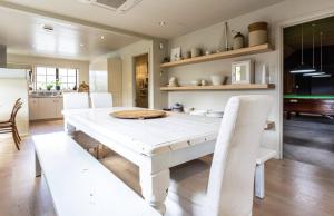 a white dining room with a white table and chairs at The Billiards Room in Queenstown