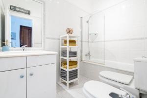 a white bathroom with a sink and a toilet at Mouzinho Blueapartment in Cabanas de Tavira