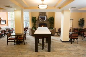 a dining room with tables and chairs and a fireplace at Holiday Inn Express Hotel & Suites Cherokee-Casino, an IHG Hotel in Cherokee