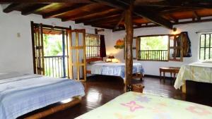 a bedroom with two beds in a room with windows at Hostel Casa de Nelly in San Agustín