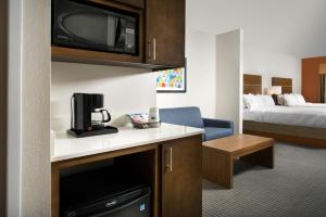 a hotel room with a kitchen and a room with a bed at Holiday Inn Express & Suites Bay City by IHG in Bay City +23 photos