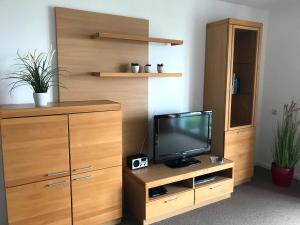 a living room with a tv and a wooden cabinet at Steiner Strandappartements Appartement 205 Seeseite in Stein