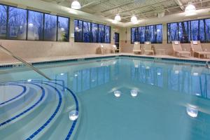 ein Pool mit blauem Wasser in einem Gebäude in der Unterkunft Holiday Inn Express Hotel & Suites - Novi, an IHG Hotel in Novi
