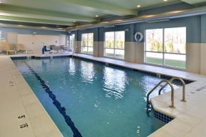 a large swimming pool with blue water in a building at Holiday Inn Express & Suites Farmington Hills - Detroit, an IHG Hotel in Farmington Hills