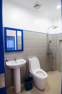 La salle de bains est pourvue d'un lavabo, de toilettes et d'un miroir. dans l'établissement Skytel Palawan, à Puerto Princesa
