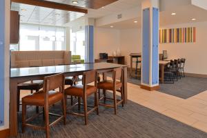 a conference room with a table and chairs at Holiday Inn Express & Suites Farmington Hills - Detroit by IHG in Farmington Hills +28 photos