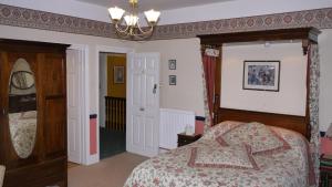 a bedroom with a bed and a chandelier at Leadon House Hotel in Ledbury