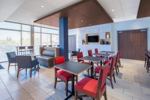 un comedor con mesas, sillas y ventanas en Holiday Inn Express & Suites - Chico, an IHG Hotel, en Chico