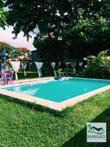 a swimming pool in the grass next to a yard at Pousada Mansão Férias in Cabo Frio