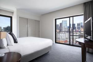 a hotel room with a bed and a large window at Mantra on Russell in Melbourne