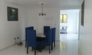 une salle à manger avec des chaises bleues et une table dans l'établissement Amplio y acogedor apartamento, à Santiago de los Caballeros