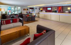 un vestíbulo de hotel con sofás y un bar en Holiday Inn Express Manchester - Salford Quays, an IHG Hotel en Mánchester