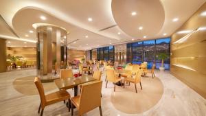 a restaurant with tables and chairs and windows at Holiday Inn Express Nantong Downtown, an IHG Hotel in Nantong