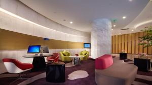 a lobby with red and yellow chairs and a desk at Holiday Inn Express Nantong Downtown, an IHG Hotel in Nantong
